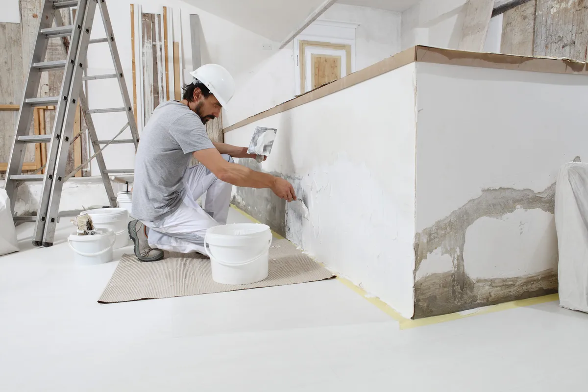Gipser verputzt eine Wand im Innenraum